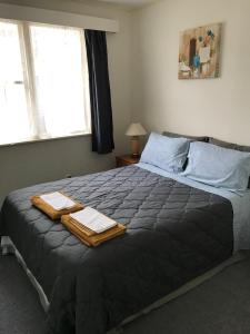 a bedroom with a bed with two towels on it at The Bivvy at Hutt Central in Lower Hutt