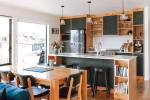 a kitchen with a wooden table and chairs and a counter at B e a c h H o u s e X I V in Bicheno