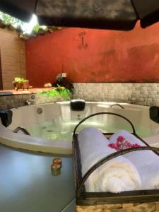une baignoire avec un panier de serviettes à l'intérieur dans l'établissement Pousada Fênix, à Pirenópolis