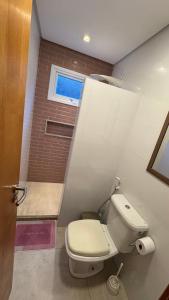 a bathroom with a white toilet and a window at Casa condominio Aldeiá de jacuipe in Barra de Jacuípe