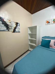 a bedroom with a bed and a painting on the wall at Suíte com ar condicionado próximo ao Estádio Mangueirão in Belém