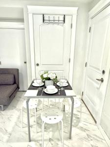 a white living room with a table and chairs at Cozy and Modern 2br guesthouse in Vancouver