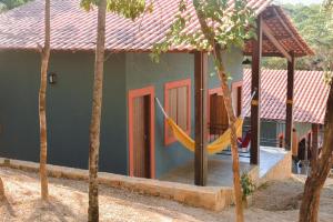 a house with a hammock in front of it at Hospedaria Lunar in Palmeiras