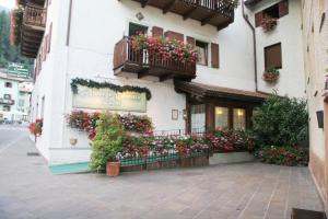 a building with flower boxes on the side of it at Albergo Garnì Cavento in Pinzolo