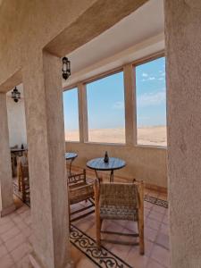 a room with a table and chairs and windows at Palais D'escapade in El Karia