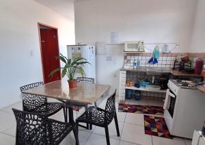 a kitchen with a table and chairs and a refrigerator at Quarto UP perto do Centro e Praias AR TV Wifi Cozinha Lavadora in São Luís