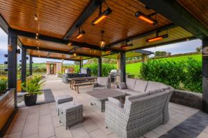 an outdoor patio with furniture and a wooden pergola at Rosies Cottage in Rostrevor