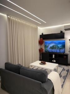 アブハにあるNight Hillsのソファとテレビのあるリビングルーム