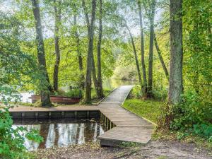un puente de madera sobre un estanque en un parque en 4 star holiday home in Ry, en Ry