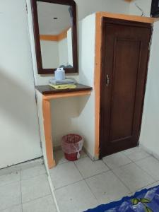 baño con espejo, lavabo y puerta en Hotel media luna, en San Luis Potosí