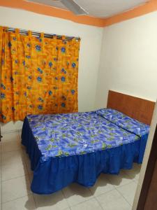 Un dormitorio con una cama con sábanas azules y una cortina. en Hotel media luna, en San Luis Potosí
