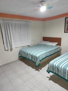Un dormitorio con dos camas y un ventilador de techo. en Hotel media luna, en San Luis Potosí