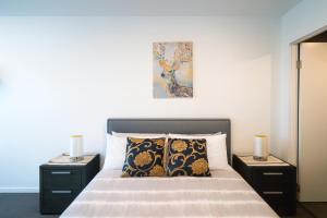 a bedroom with a bed with two night stands and two lamps at 3 BRs topfloor view@Heart of Canberra free parking in Canberra