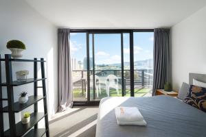 a bedroom with a bed and a large window at 3 BRs topfloor view@Heart of Canberra free parking in Canberra