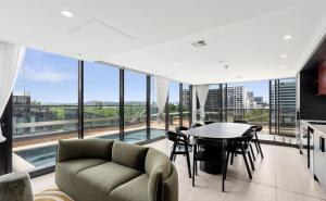 a living room with a table and chairs and large windows at 3 BRs topfloor view@Heart of Canberra free parking in Canberra