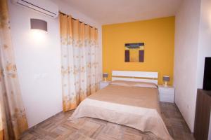 a bedroom with a bed and a yellow wall at Ascoltando Il Mare in Lido Signorino