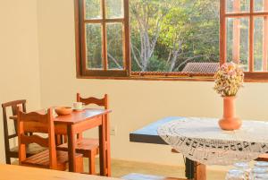a dining room with a table and a window at Hospedaria Lunar in Palmeiras