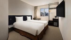 a hotel room with two beds and a television at ibis Ambassador Seoul Insadong-Newly renovated in 2025 in Seoul +43 photos