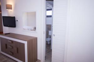 Lido SignorinoにあるAscoltando Il Mareのバスルーム(トイレ付)、壁にテレビが備わります。