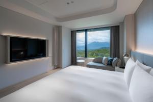 a hotel room with a large bed and a large window at Chalet Ivy Weiss, Niseko in Kutchan