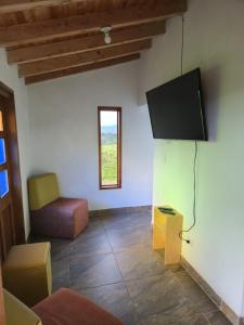 Carmen de ViboralにあるFinca Completa Carmen Viboral Naturaleza y Privacidadのリビングルーム(テレビ、椅子付)