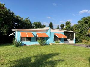 una casa azul con techos naranjas en un patio en Pineapple Cottage 2 bedroom, en Jensen Beach