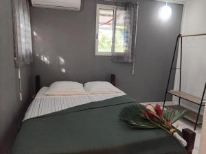 a bedroom with a bed with a window and flowers on it at Résidence Belle Place Palmier in Saint-François