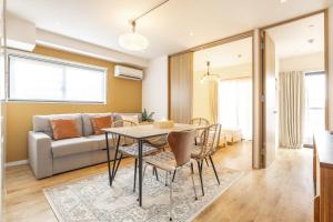 uma sala de estar com uma mesa, cadeiras e um sofá em GrandTree Hotel - Specutaclor Skytree view! em Tóquio