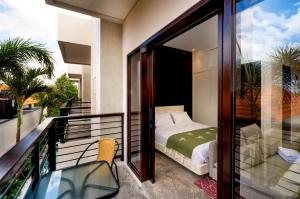 een slaapkamer met een bed op een balkon bij Harmoni Lane Studios in Seminyak
