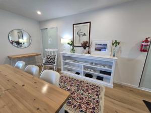 a living room with a table and a dining room at Flatrock Penthouse Ulladulla in Ulladulla