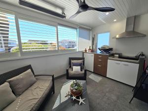 a living room with a couch and a kitchen at Flatrock Penthouse Ulladulla in Ulladulla