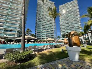 a resort with a pool and palm trees and buildings at Icon Vallarta in Puerto Vallarta