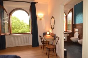 a room with a table and chairs and a bathroom at Volpicelli B&B in Civitella Alfedena