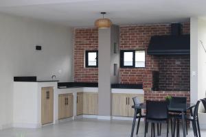 a kitchen with a brick wall and a table and chairs at Epic Sun in Punta Cana