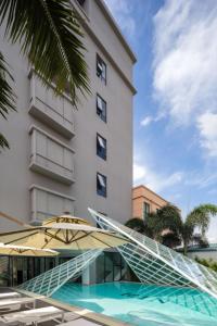 三亜市にあるMin Xiangmi Design Residence (Sanya Bay Phoenix International Airport Store)の階段と傘と建物のあるホテル