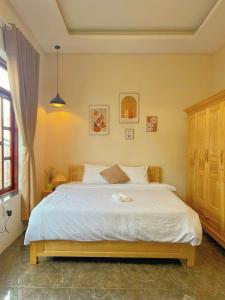a bedroom with a bed with a white bedspread at The Brownhaven Đà Lạt in Da Lat +36 photos