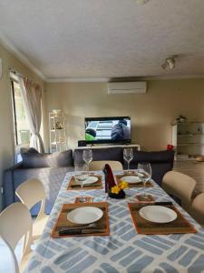 a dining room table with plates and wine glasses at Entire independent 3 bdrm house in Algester