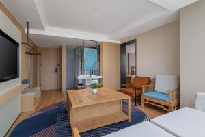 una sala de estar con un sofá y una mesa en Holiday Inn Express Kunming Railway Station by IHG, en Kunming