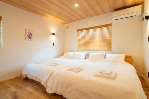 a large white bed in a room with a window at Natural Base 上富良野新築戸建て 駐車場3台 ファミリーオススメ マーケットすぐ in Kami-furano +80 photos