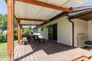 a wooden patio with a table and a grill at Hyde Park Haven - your home away from home - minutes north of Logan and USU in Hyde Park