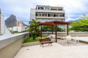 un patio avec un banc et un gazebo sur un bâtiment dans l'établissement Flat Leblon Rio, à Rio de Janeiro