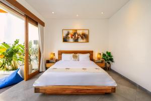 une chambre avec un grand lit et une grande fenêtre dans l'établissement Arkarhea Villa, BRAND NEW! 2BR Tropical Villa with Pool, Canggu, à Dalung