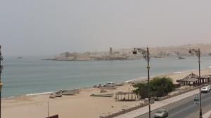 een uitzicht op een strand met boten in het water bij Alafeeh Corniche Hotel Apartments in Sur