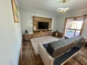a living room with a couch and a flat screen tv at Casa de Praia da Família Martins in Tramandaí