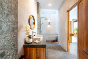 une salle de bain avec une baignoire, un lavabo et un miroir dans l'établissement Arkarhea Villa, BRAND NEW! 2BR Tropical Villa with Pool, Canggu, à Dalung 26 autres photos