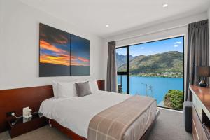 a bedroom with a large bed and a large window at Charming Lakeview Home with Remarkable Views in Frankton Wharf