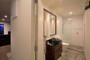 a white bathroom with a sink and a toilet at Charming Lakeview Home with Remarkable Views in Frankton Wharf +27 photos