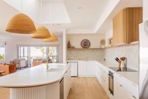 Una cocina con gabinetes blancos y una encimera blanca. en Torretta by the Bay, en Dunsborough