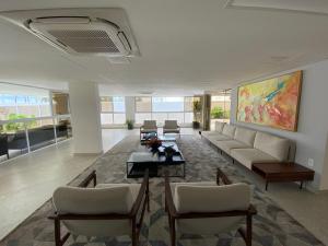 a living room with a couch and a table and chairs at Bela Hospedagem - Puerto Ventura, frente mar e ao lado do food park in João Pessoa
