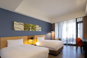 a hotel room with two beds and a window at Lakeshore Hotel Hualien in Hualien City
